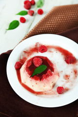 Panna Cotta with raspberry sauce, on wooden background