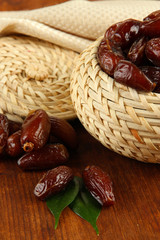 Dried dates in basket on wooden background