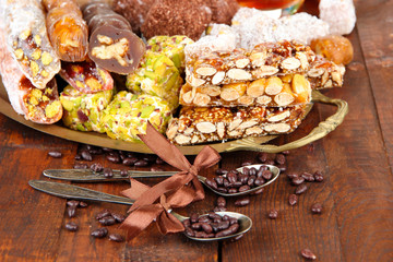 Tasty oriental sweets on tray, on grey wooden background