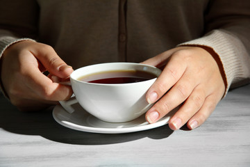 Hands holding mug of hot drink, close-up