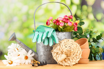 Gardening tools and flowers on wooden table, outdoors