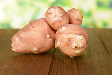 Topinambur roots on table on bright background