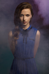 Young girl in a dress in smoke