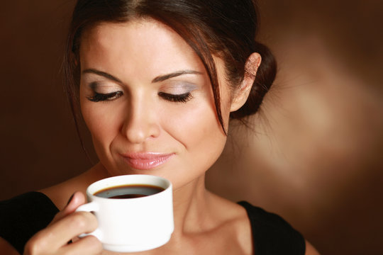 Woman with an aromatic coffee in hands.