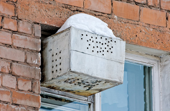 Improvised refrigerator in the window of an apartment house