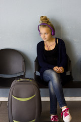 Girl with headphones waiting to travel