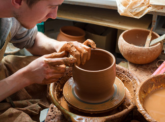 hands of a potter, creating an earthen jar on the circle