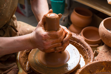 hands of a potter, creating an earthen jar on the circle