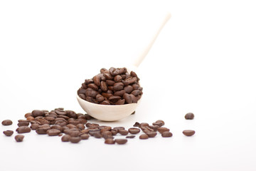 wooden spoon with coffee beans, isolated