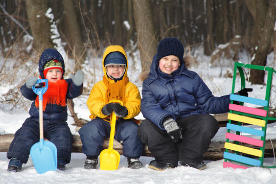 three boy play on snow