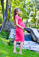 young pregnant woman in park