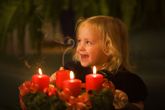 Kind mit Adventskranz zu Weihnachten