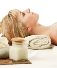 Obraz na płótnie Canvas A beautiful woman enjoying spa treatment is lying on a towel