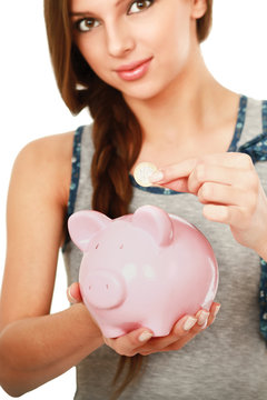 Young beautiful woman standing with piggy bank (money box)