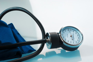 Sphygmomanometer on blue, reflective background