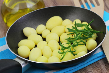 Baby potatoes with fresh rosemary in frying pan