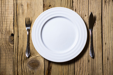 Fish cutlery and plate on rustic wooden table