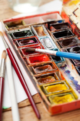 Watercolor paint box and brushes for painting .