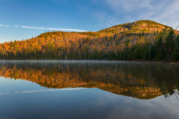 Naklejka premium Lake Reflections of fall foliage. Colorful autumn leaves shed re
