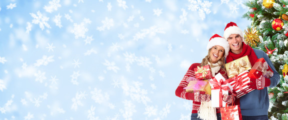 Happy christmas couple over snowy background.