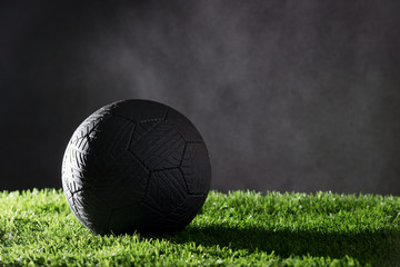 Black soccer ball on grass