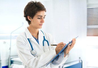 Doctor writing on a clipboard