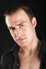 A portrait of a man standing isolated on black background