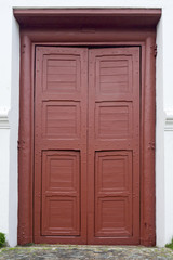 Red entrance door in front of residential house