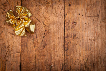 Small golden ribbon on wooden background