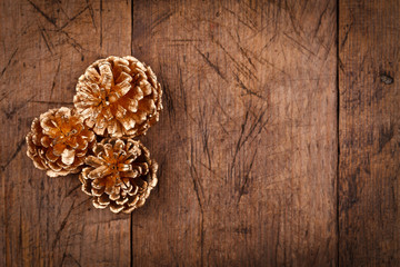 Golden pine cones on wooden table