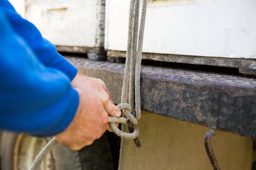 Beekeeper Tying Rope To Hook Of Truck