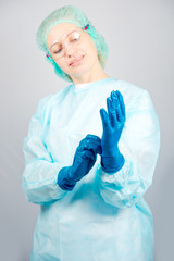 surgeon woman in sterile gown dresses sterile gloves