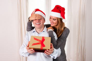 Young Happy Couple with Presents on rug at Christmas