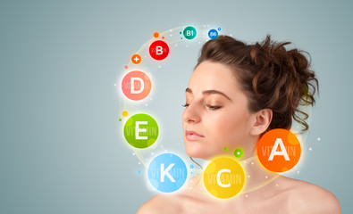 Pretty young girl with colorful vitamin icons and symbols