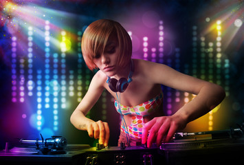 Obraz premium Dj girl playing songs in a disco with light show