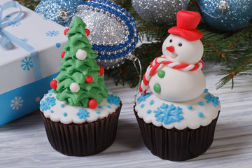 Two muffins Christmas spruce with toys and a snowman