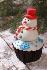 Cupcake Christmas snowman on snow. vertical