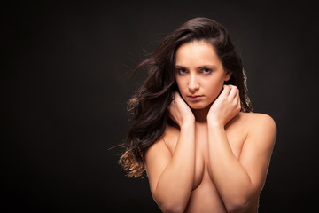 Fototapeta premium Young intimate brunette woman beauty portrait against dark backg