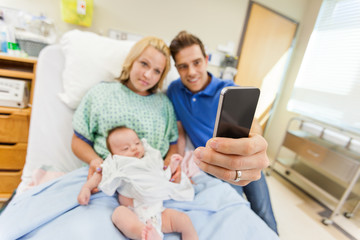 Man With Woman And Babygirl Taking Selfportrait Through Cell Pho