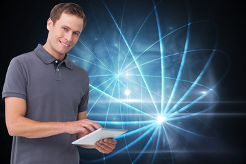 Composite image of smiling young man with tablet computer