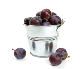 bucket of plums isolated on white