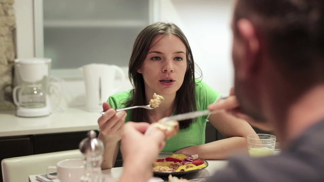 Young couple talking during meal in the kitchen