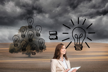 Composite image of businesswoman holding tablet and looking up