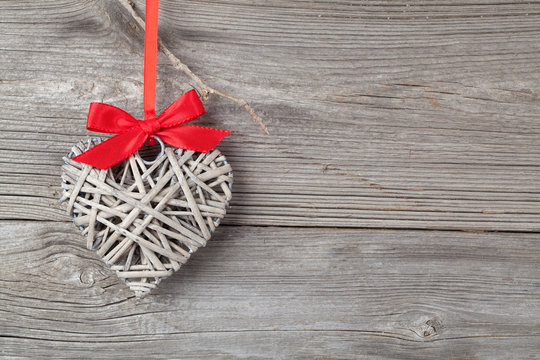 one heart with red bow, on wooden background