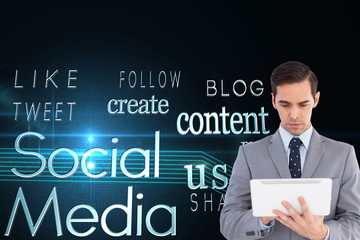 Composite image of businessman holding a tablet computer