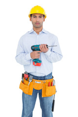 Serious handsome young handyman holding drill