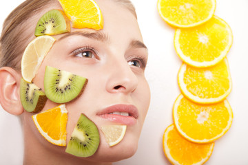 Smiling woman with fruit mask on her face isolated