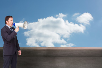 Composite image of standing businessman shouting through a megap