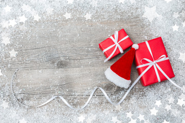 Gift boxes and Santa's hat on wooden background