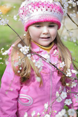 beautiful little girl near a flowering tree